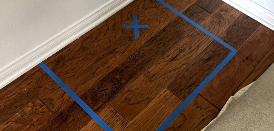 Floor with a square of blue tape marking trouble area